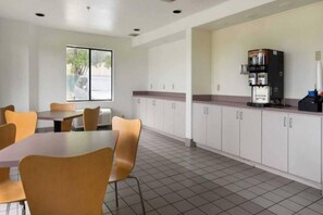 A clean, modern kitchen with white cabinets, a coffee machine, and a window providing natural light. - 2 Full Beds | Non-Smoking (Dallas)