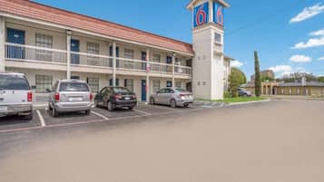 Un motel doté d’un parking, d’un bâtiment à deux étages et d’une tour sur laquelle est inscrit le chiffre 66.