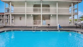 Un bâtiment à deux étages avec une piscine devant.