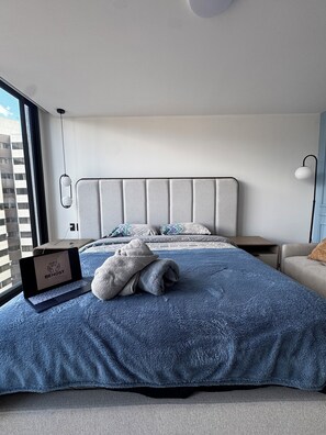 A modern hotel room with a large bed, a laptop, and a view of the city. - Beautiful view (Quito)