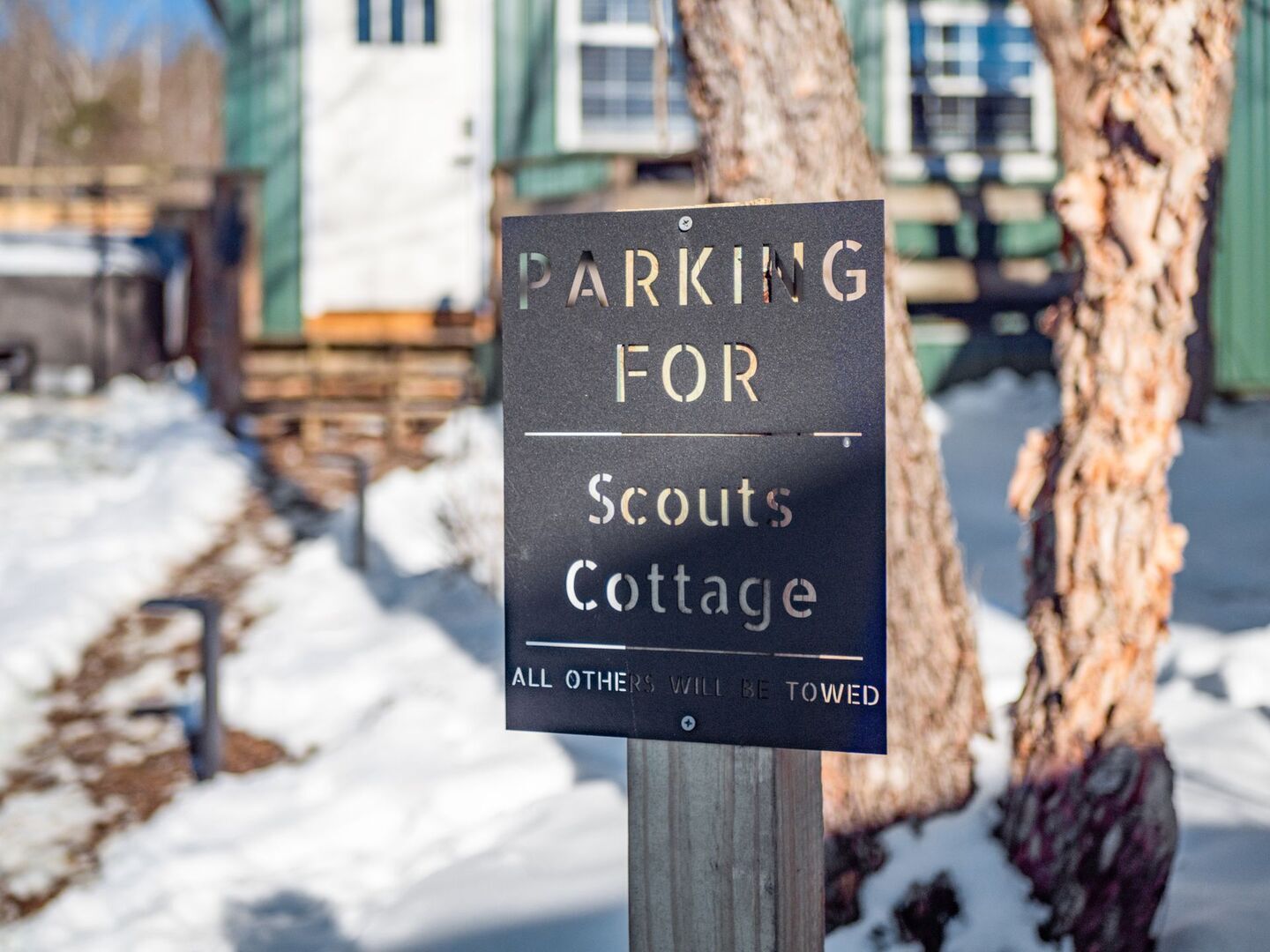 Ein Schild, das anzeigt, dass die Parkplätze für Scouts Cottage reserviert sind. Fahrzeuge, die keine Berechtigung haben, werden abgeschleppt.
