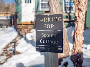 Ein Schild, das anzeigt, dass die Parkplätze für Scouts Cottage reserviert sind. Fahrzeuge, die keine Berechtigung haben, werden abgeschleppt.