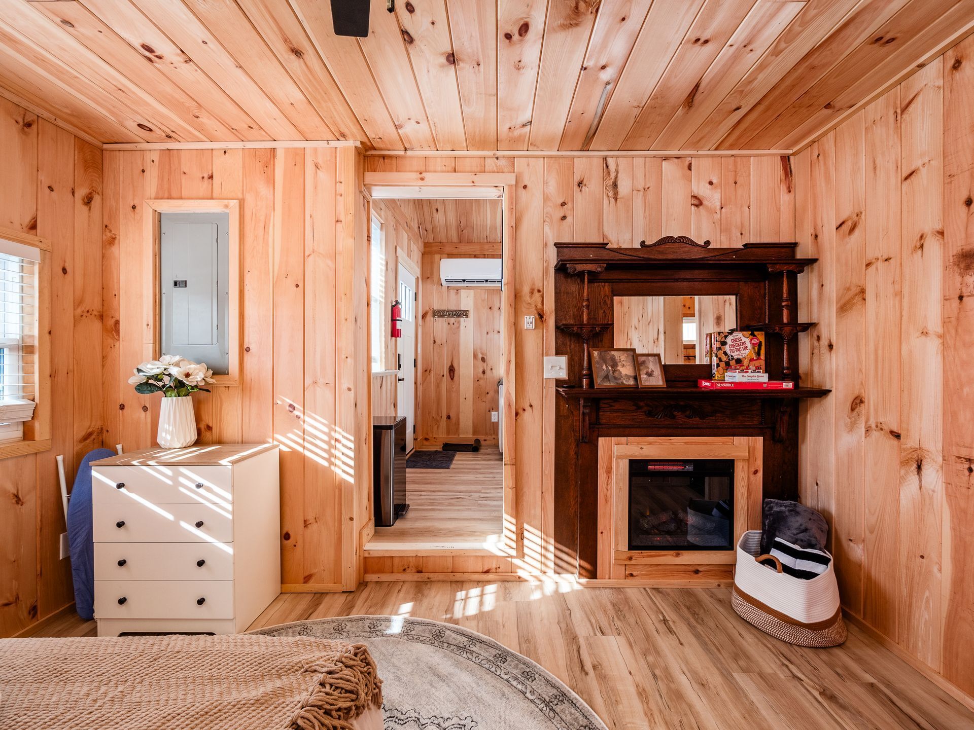 Ein Holzinterieur mit Kamin, Spiegel und einer kleinen Bücherablage.