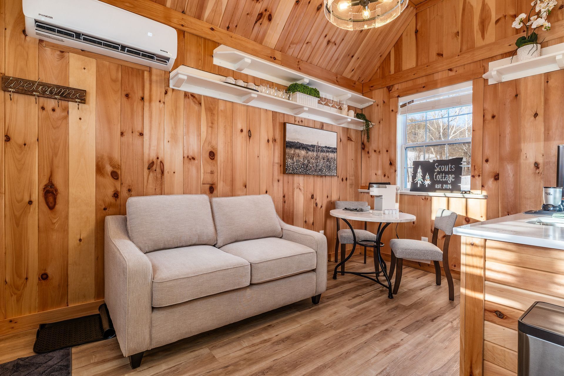 Een gezellig chaletinterieur met een bank, een eettafel en een kitchenette.