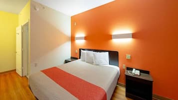 A hotel room with a bed, nightstands, and a door.