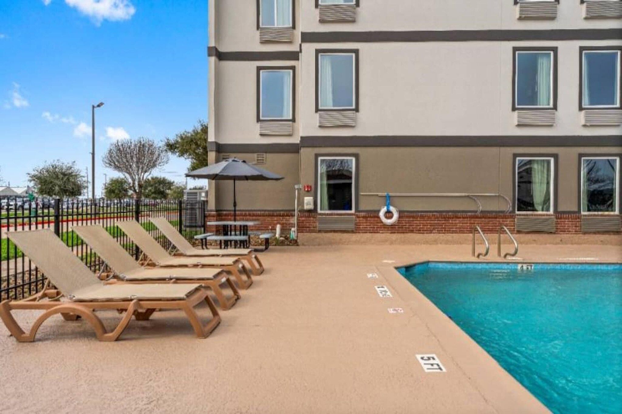 A poolside area with lounge chairs and a pool.
