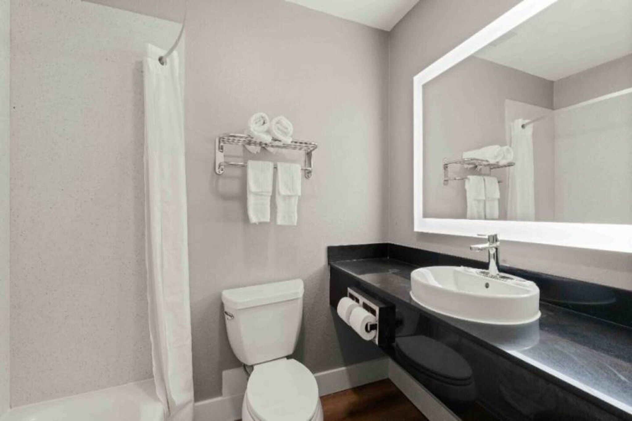 A modern bathroom with a toilet, sink, and towel rack.