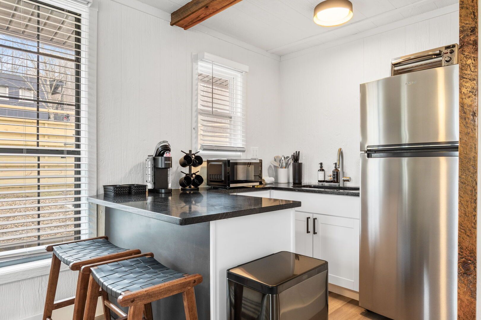 A modern kitchen with a stainless steel refrigerator, a coffee machine, and a microwave.