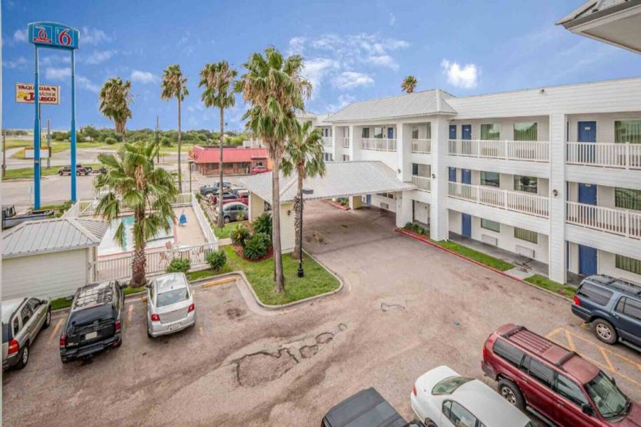 Un motel doté d’un parking, d’une piscine et d’un bâtiment à plusieurs étages.