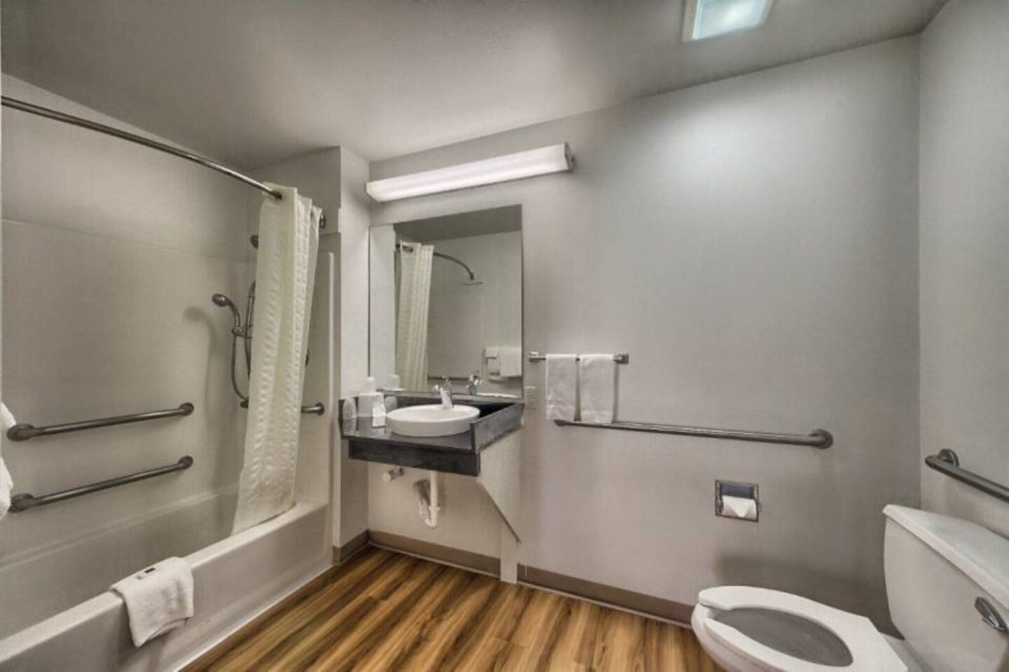 A modern bathroom with a bathtub, toilet, and sink.