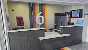 Un comptoir d’accueil avec un grand chiffre « 6 » affiché sur le mur, un détecteur d’incendie et un écran de télévision.