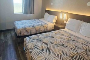 Two twin beds with patterned bedding in a hotel room.