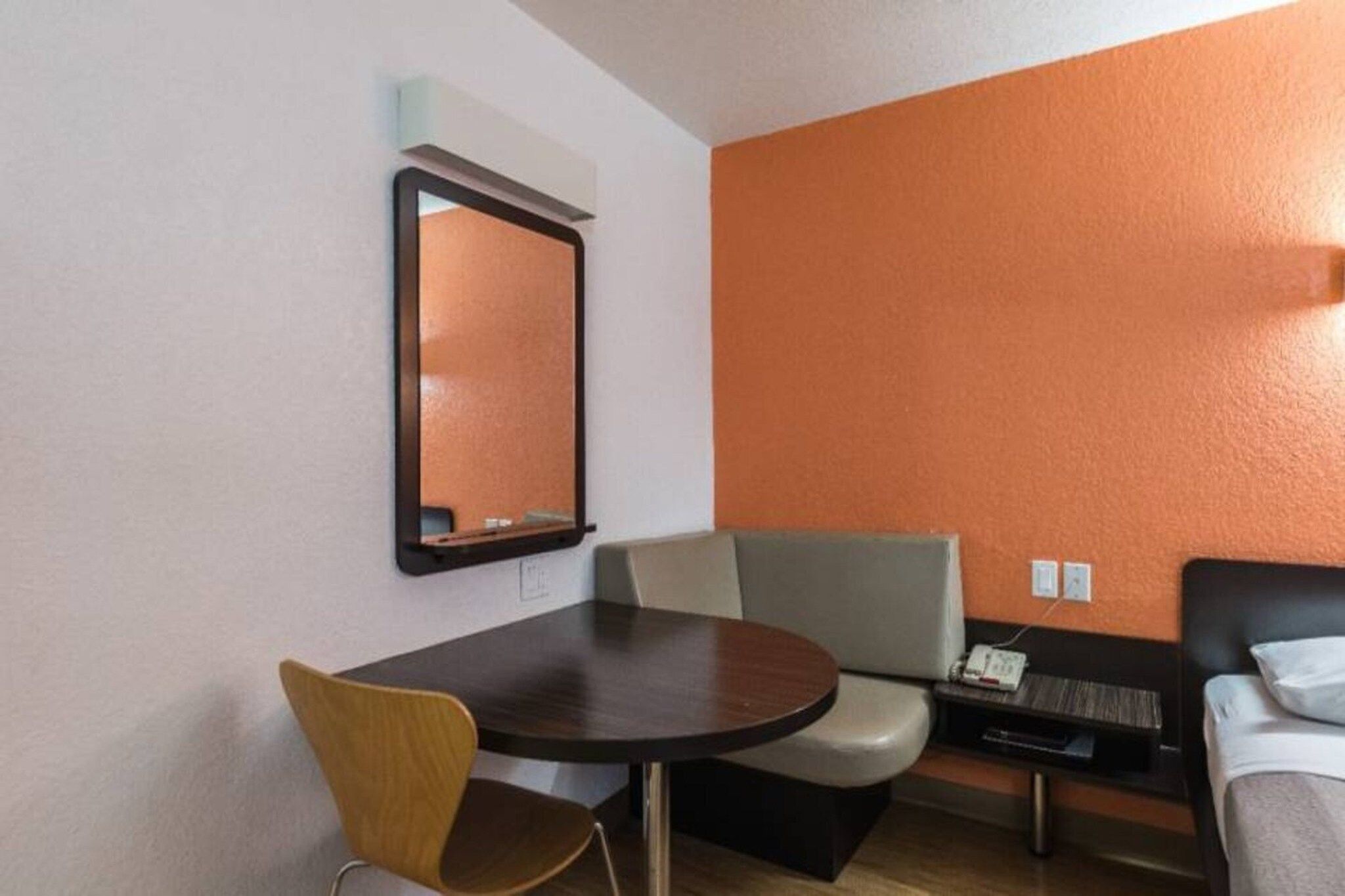Une chambre d’hôtel avec une table ronde, une chaise, un canapé et un lit.