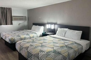A hotel room with two beds, each with patterned bedding, a bedside table with a lamp, and a window with curtains. - Sunny 2 Queen Beds Nsmk, Micfridge (Pecos)