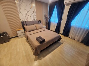 A bedroom with a bed, a nightstand, a dresser, and a window with curtains.