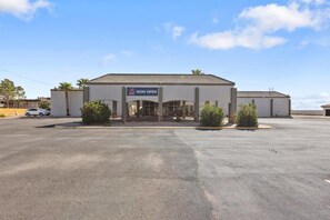A commercial building with a 'NOW OPEN' sign, a parking lot, and a clear sky. - Cozy King Bed | Nsmk, Kitchen (Pecos)