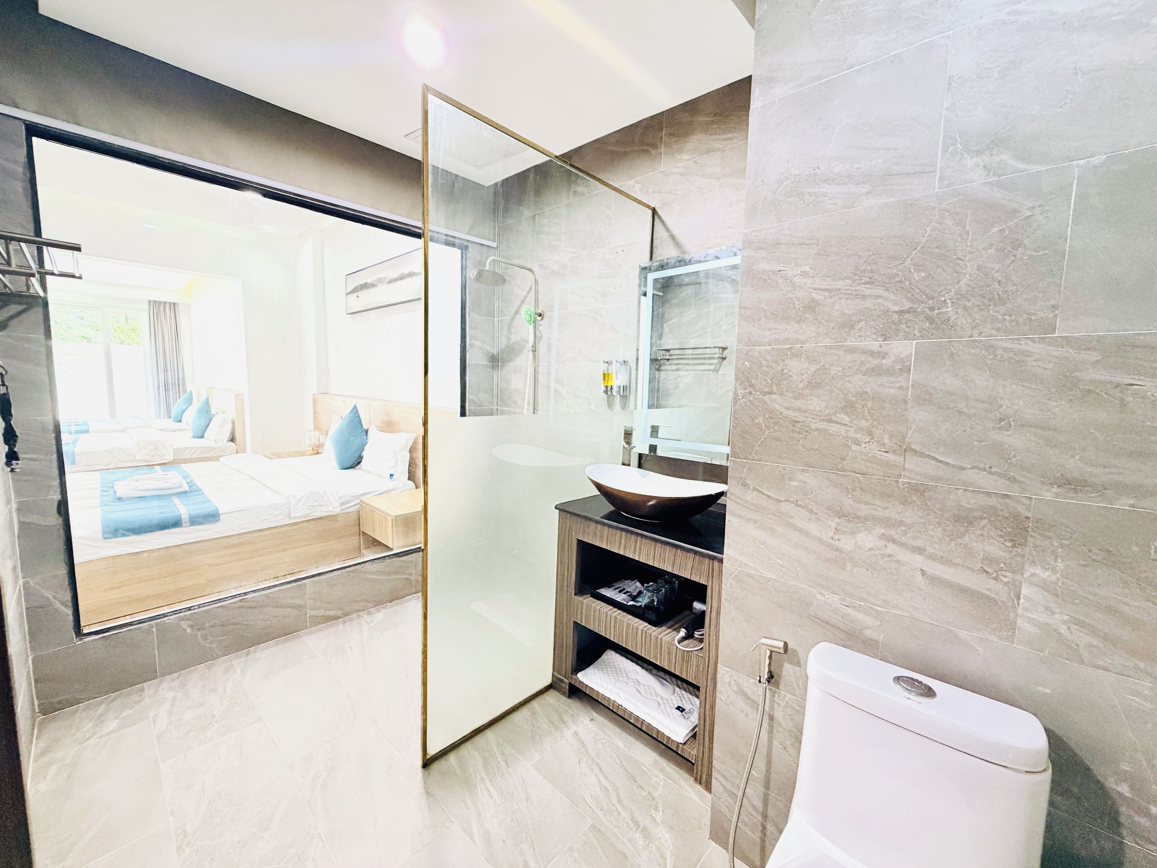 Un baño moderno con cabina de ducha de vidrio, un espejo grande y un lavabo sobre encimera.
