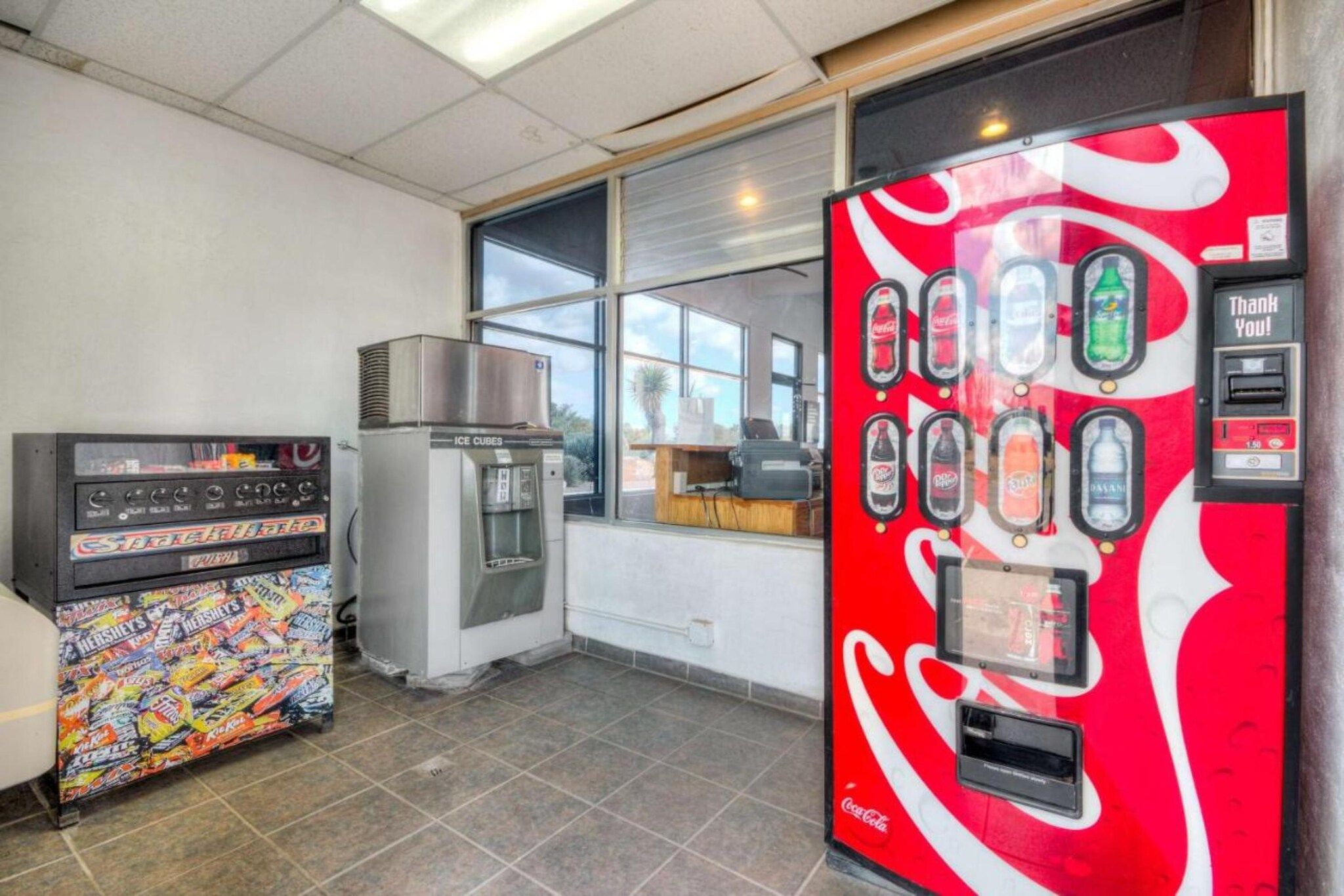 Uma área com máquinas de venda automática, incluindo uma da Coca-Cola e outra da Hershey's.