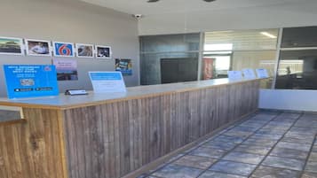 A reception desk with a wooden finish, a ceiling fan, and a tiled floor.