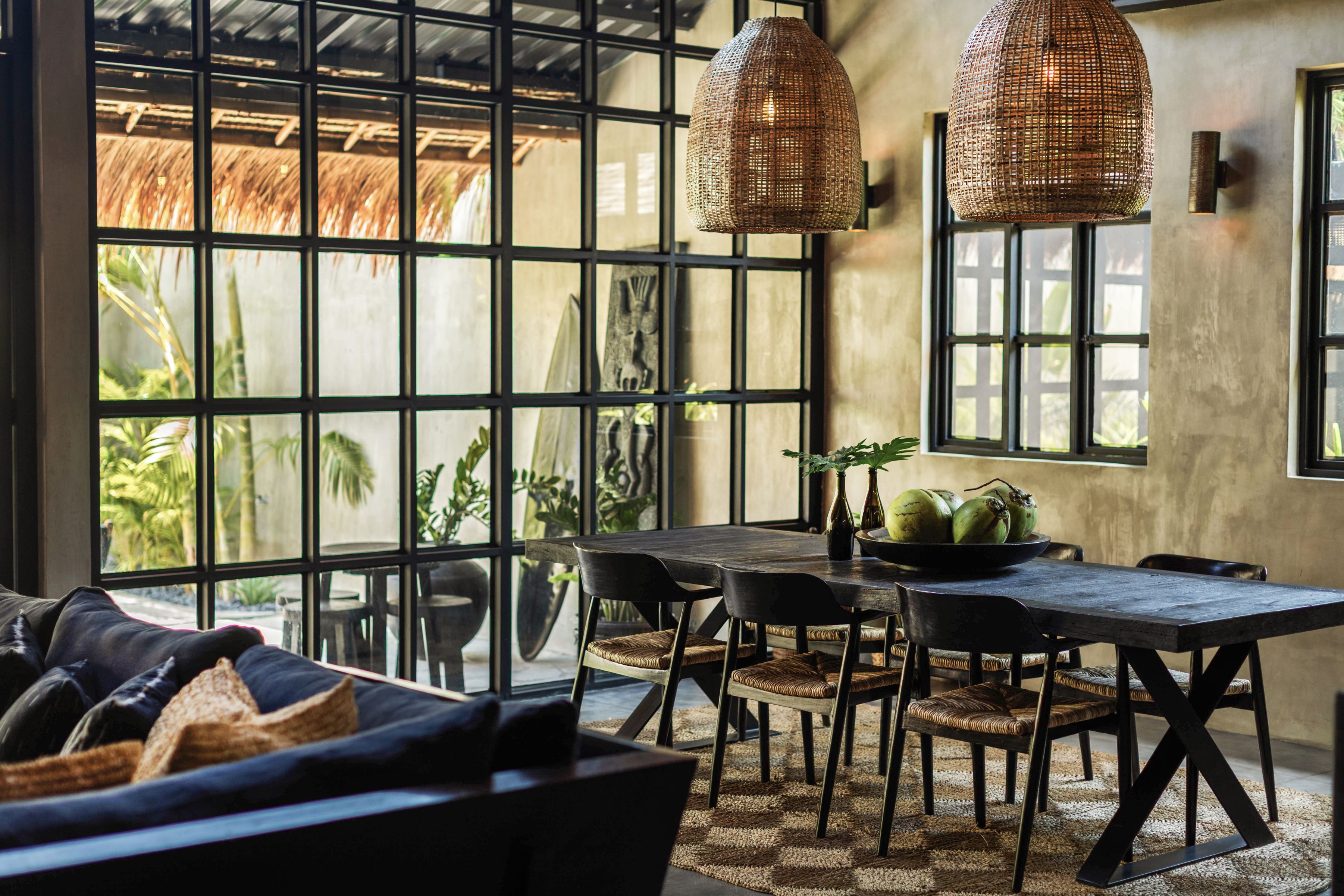 A dining area with a table, chairs, and a large window with a view of greenery.