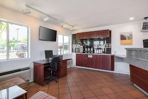 A compact office space with a desk, chair, and a kitchenette area. - Sunny 2 FULL BEDS | SMOKING (El Paso)