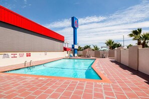 A swimming pool with a red and blue sign, a brick patio, and a clear sky. - Sunny 2 FULL BEDS | SMOKING (El Paso)