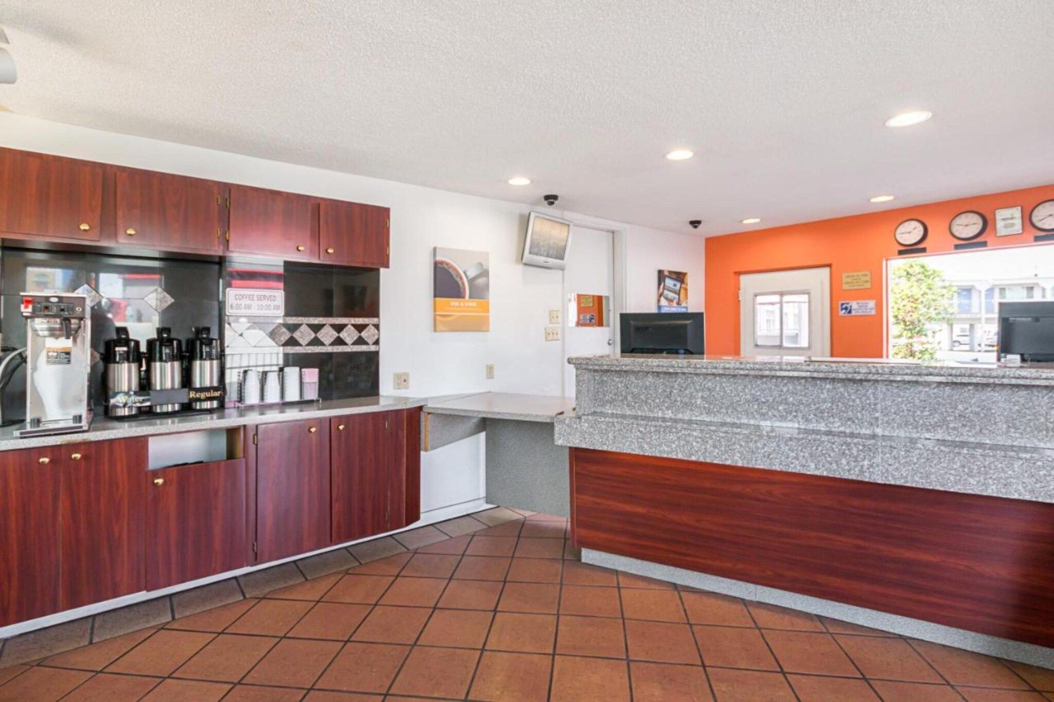 A modern kitchen with a coffee station, a counter, and a tiled floor.