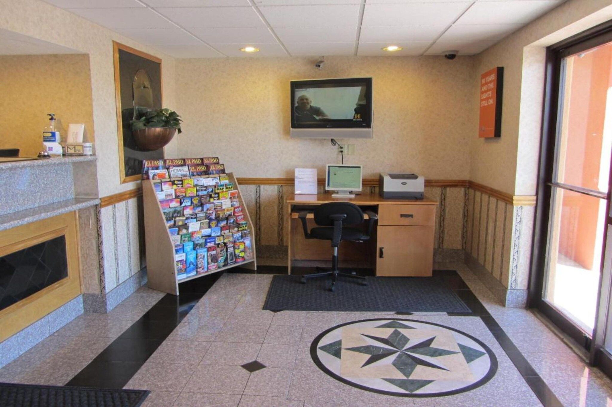 A reception area with a desk, computer, and a map display.