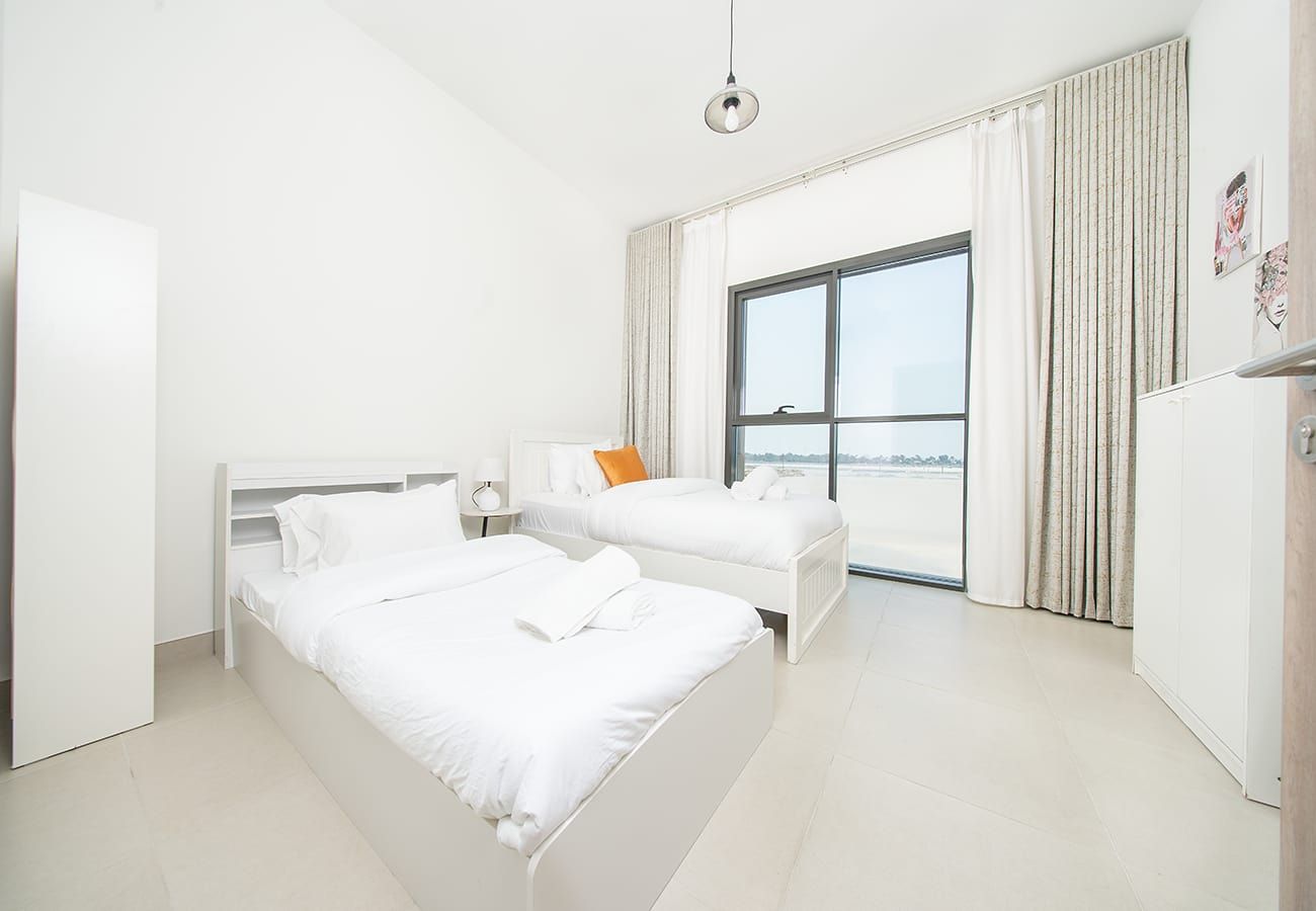 A hotel room with two beds, a large window, and a view of the city.