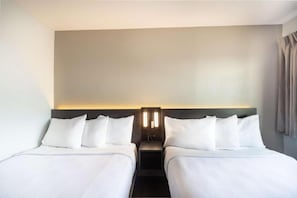 A hotel room with two beds, a nightstand, and a wall-mounted light fixture. - 2 Full Beds | Nsmk, Micfridge (Del Rio)