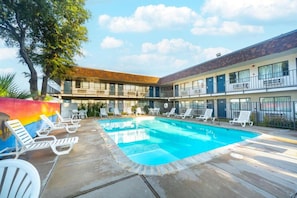 A hotel with a swimming pool, lounge chairs, and a two-story building. - 2 Full Beds | Non-Smoking (Del Rio)
