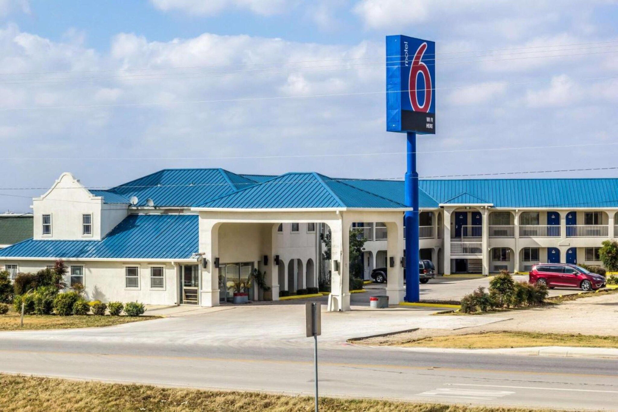 A motel with a blue roof and a prominent '6' sign.