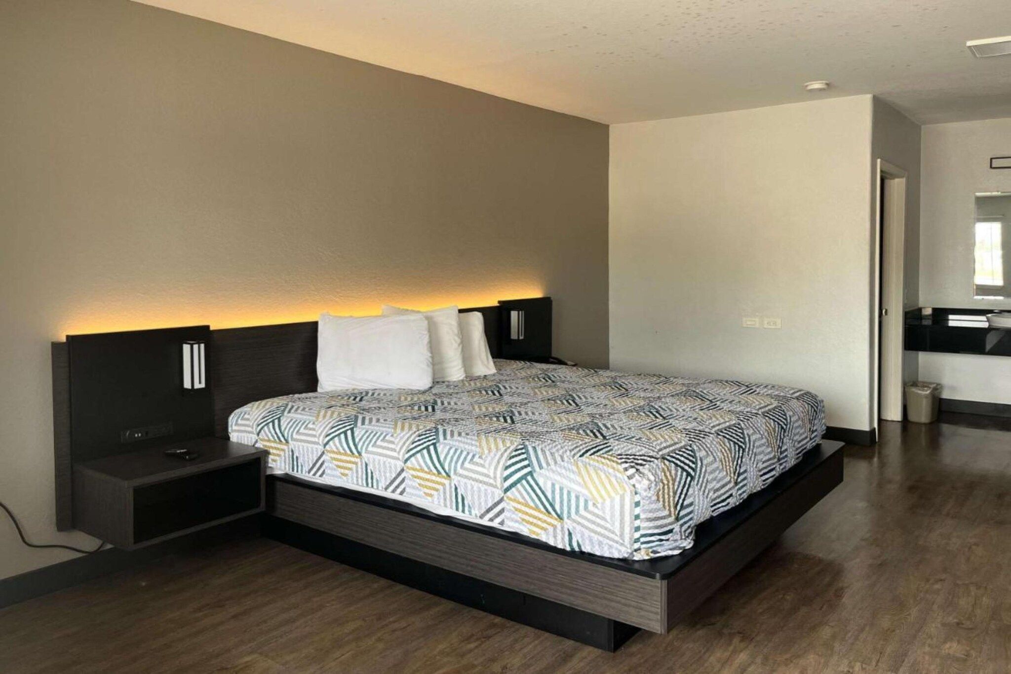 A modern bedroom with a large bed, bedside tables, and a built-in bench.