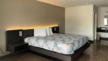 A modern bedroom with a large bed, bedside tables, and a built-in bench.