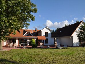 A two-story house with a patio area, a small garden, and a clear sky. - Holiday Home With 5 Bedrooms (Ribnitz-Damgarten)