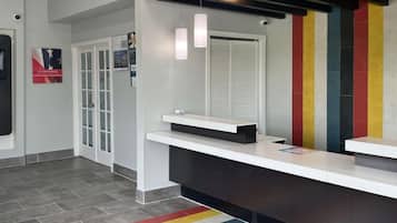 Ein Empfangsbereich im modernen Design mit einer Rezeption, einem Glastür-Eingang und einer farbenfrohen Wand.