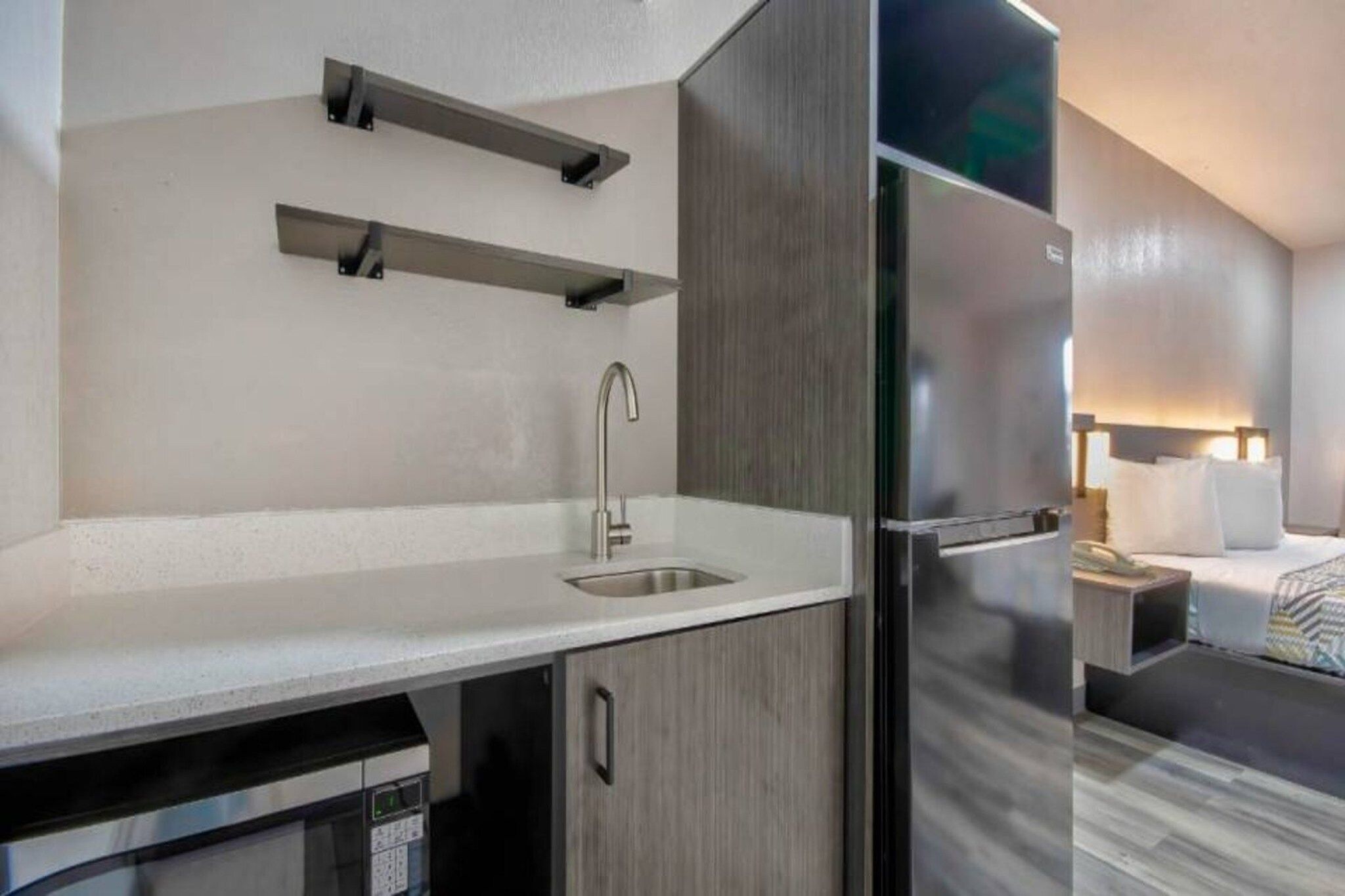A modern kitchen with a sink, a built-in oven, and a refrigerator.