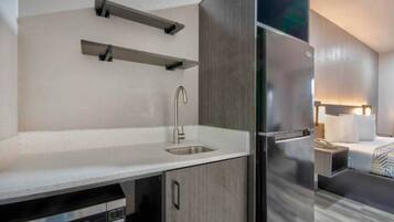A modern kitchen with a sink, a built-in oven, and a refrigerator.