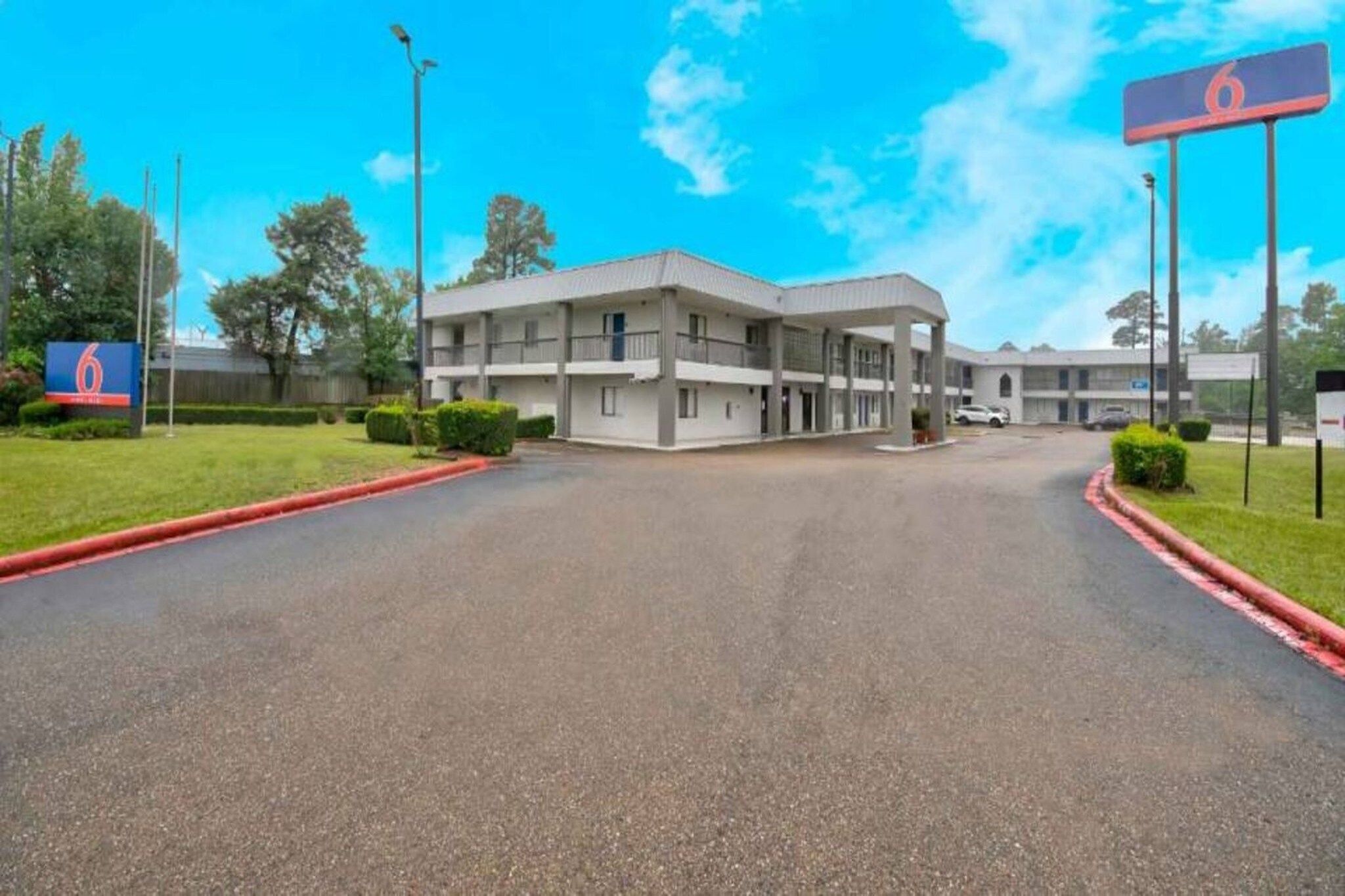 A motel with a central building and a parking lot.
