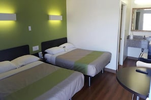 A hotel room with two beds, a small kitchenette, and a round table. - 2 FULL BEDS | SMOKING (El Paso TX)