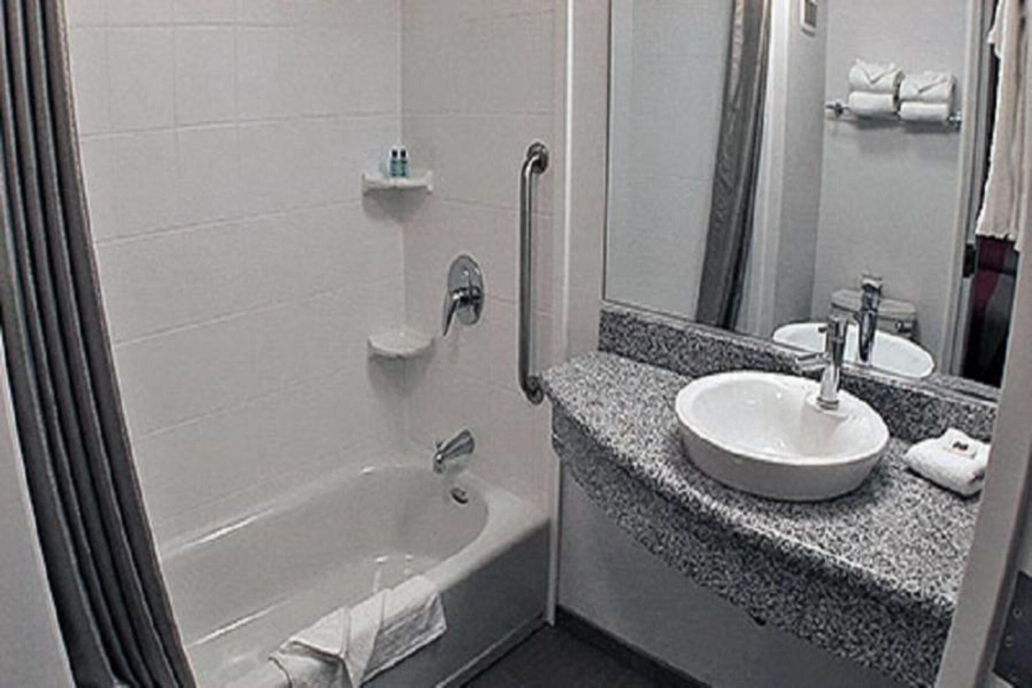 Un baño con bañera, lavamanos y espejo.