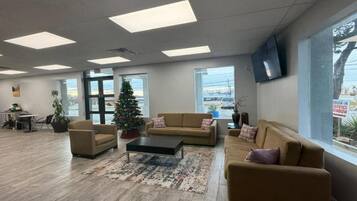 A spacious lobby with a Christmas tree, sofas, a coffee table, and large windows.