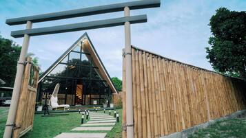 Un bâtiment moderne avec une façade en verre, une clôture en bois et un ciel dégagé.