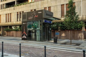 A modern building with a glass entrance, a sign reading 'SANT'AIMOGNO,' and a small tree beside it. - Apartment in Milan with 1 bedrooms sleeps 2 (Milan)