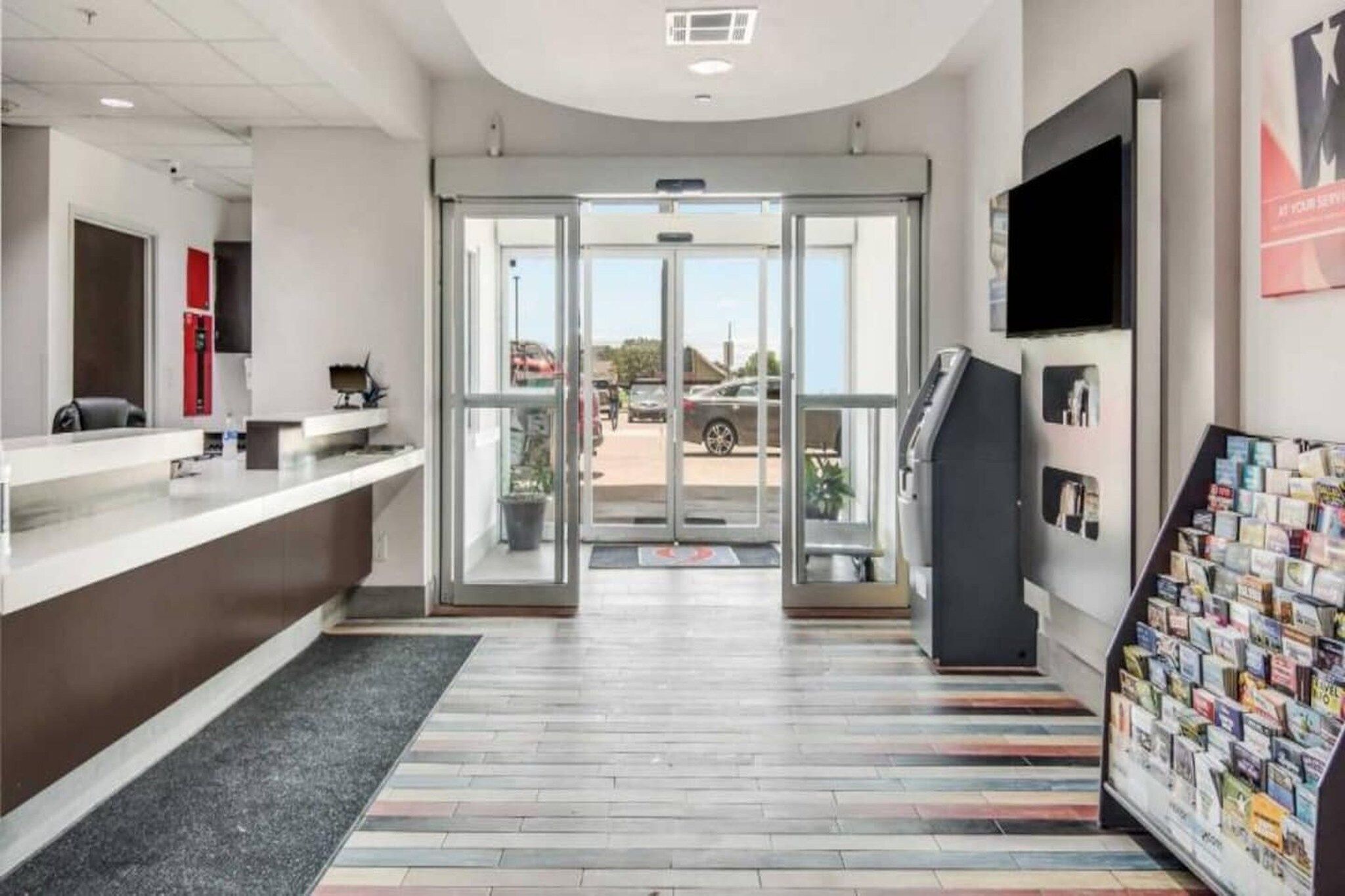 A reception area with a counter, a magazine rack, and a door leading outside.