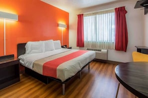 Una camera d'albergo con un letto, comodini, una scrivania e una sedia.