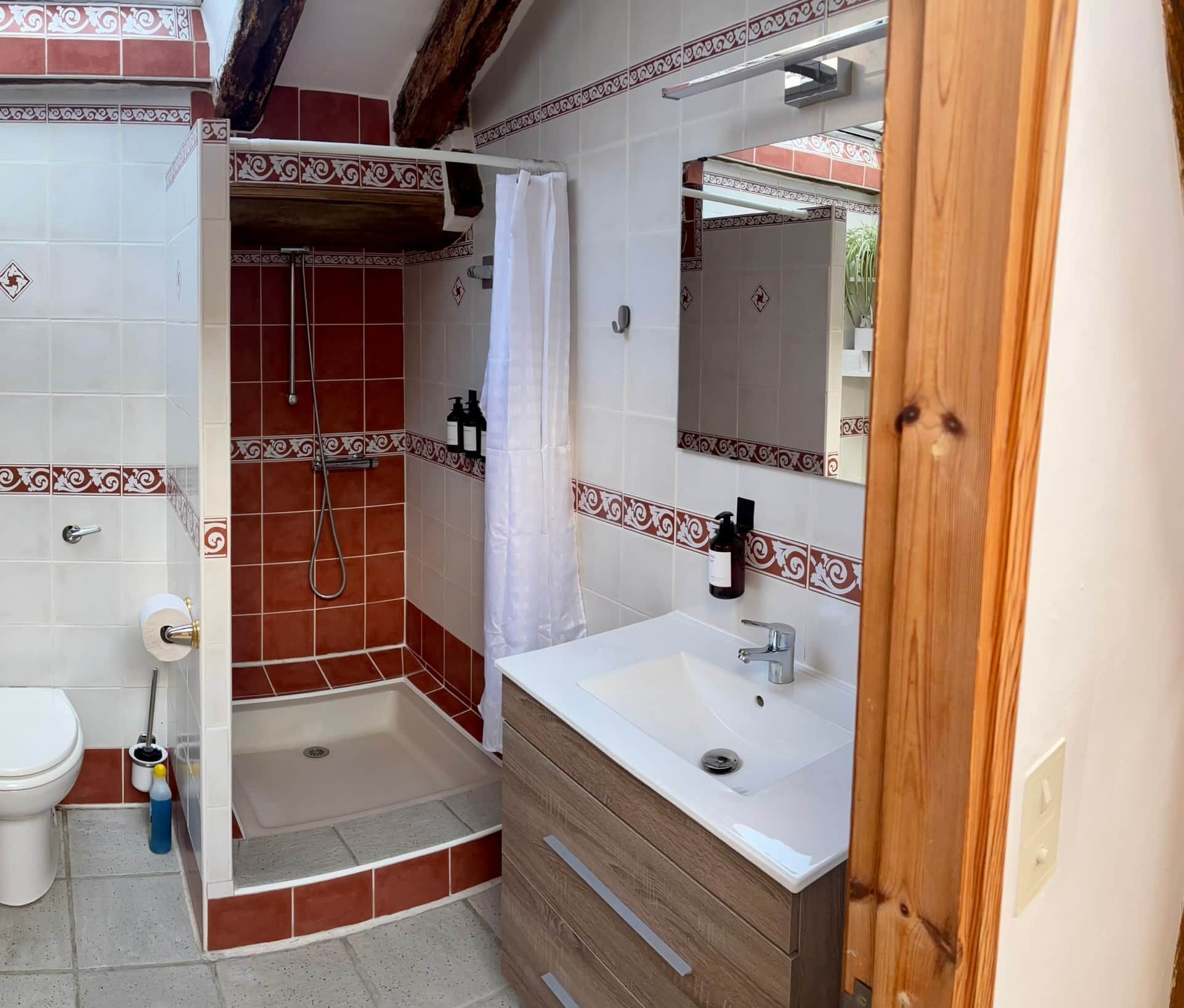 A bathroom with a shower, toilet, and sink.
