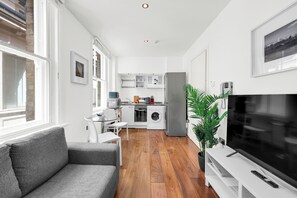A modern apartment with a living room, kitchen, and dining area. - Sterling House by City Living  (London)