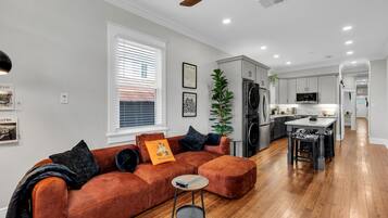 A modern living room with a sectional sofa, a small side table, and a ceiling fan.