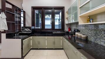 A kitchen with a window, cabinets, and a tiled backsplash.
